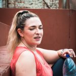 a woman sitting on a bench holding a water bottle