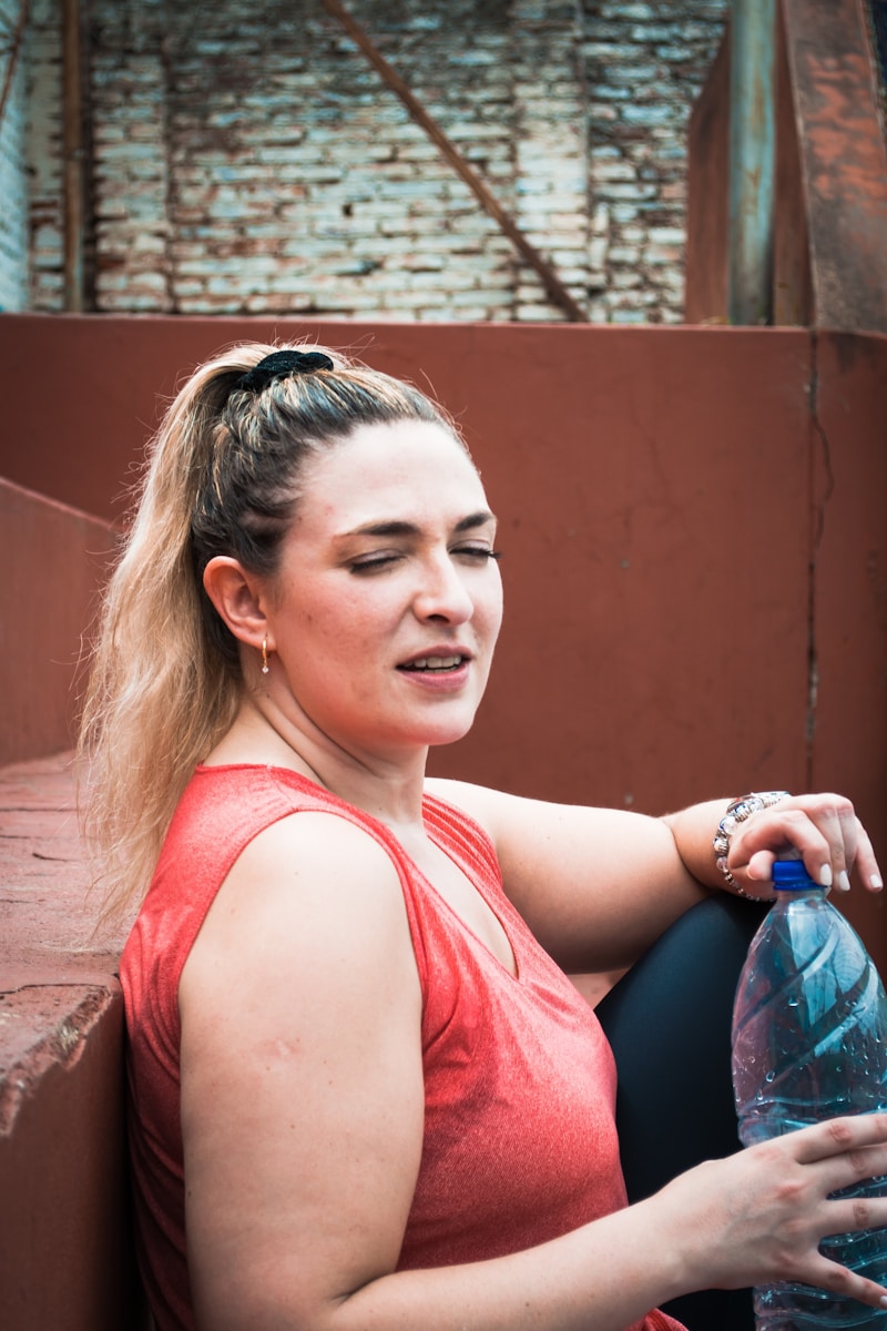 a woman sitting on a bench holding a water bottle