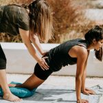 woman in black tank top and black shorts kneeling on mat