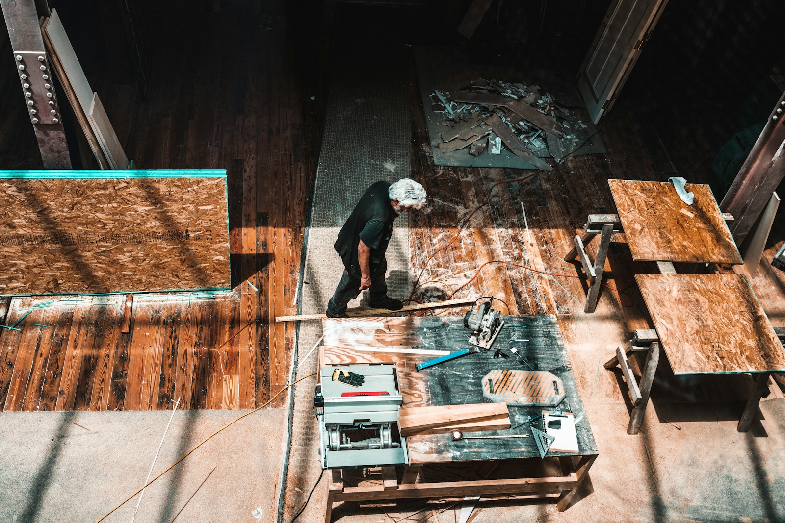 man standing beside brown wooden table